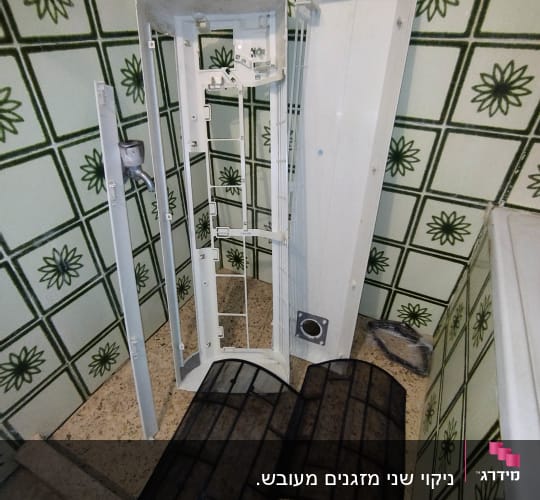 חלקי מזגן מפורקים על רצפה עם אריחים ירוקים